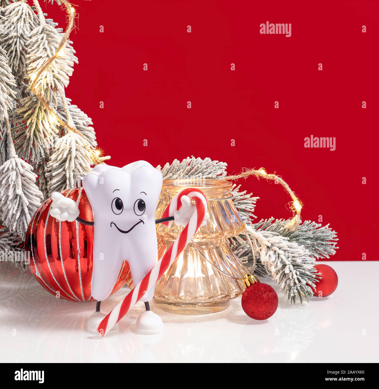 Dentist Happy Merry Christmas and New Year composition with healthy tooth holding candy cane. Gift card banner web template with copy space. Stock Photo