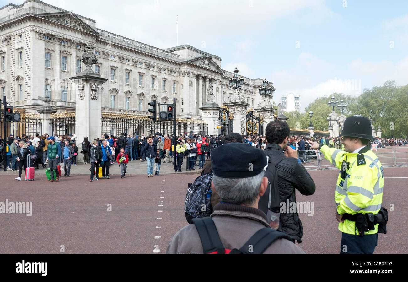 Policeman directs tourists Buckingham Palace London England Stock Photo