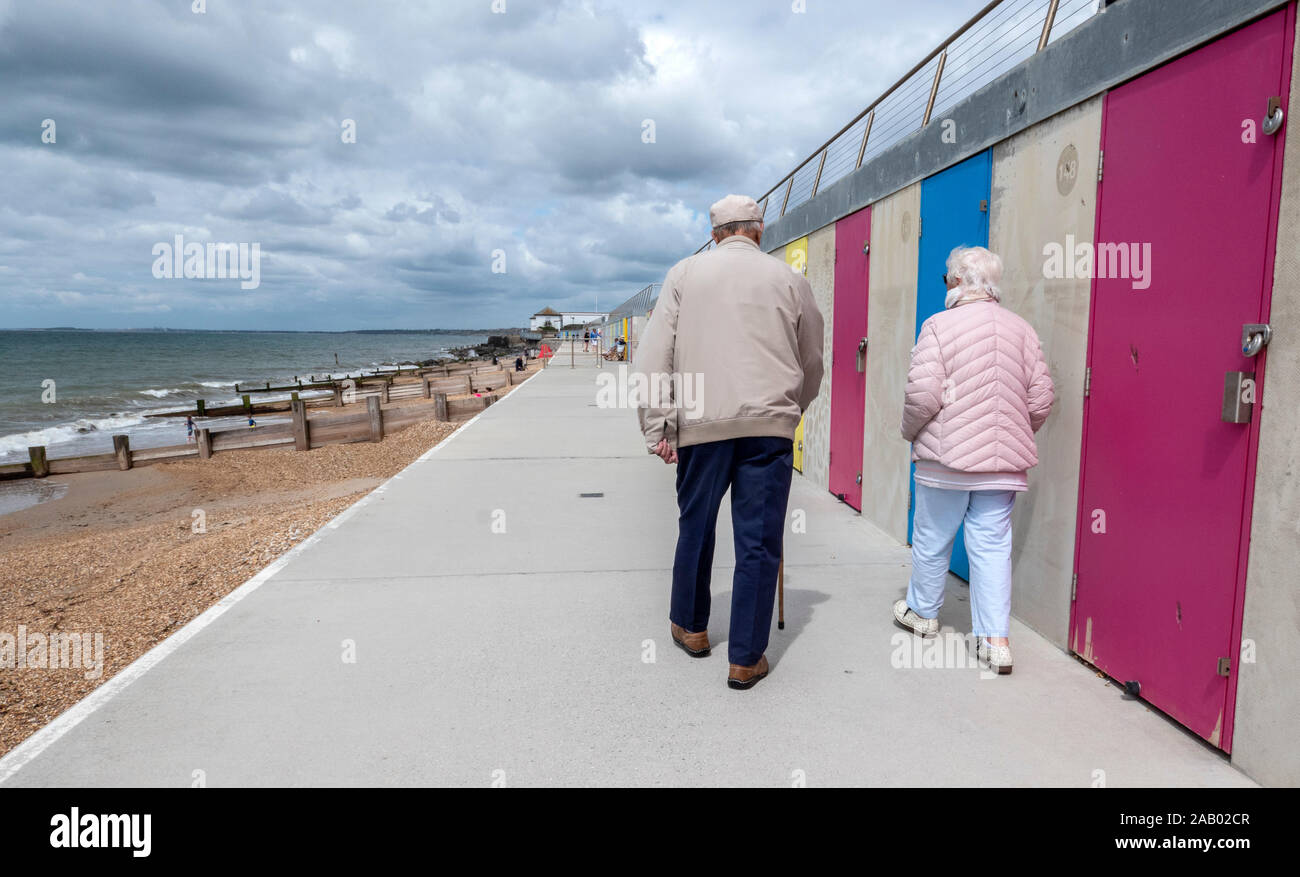 Elderly couple Milford-On-Sea beach huts Hampshire England Stock Photo