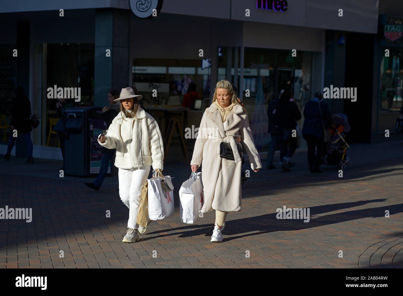 Two ladies in cream & white, out shopping Stock Photo