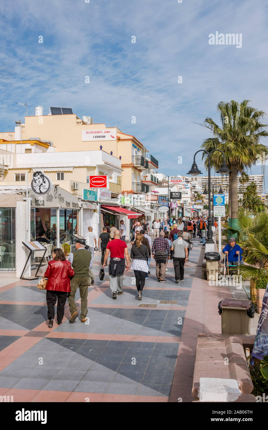 People strolling beach promenade Carihuela, with bars and restaurants