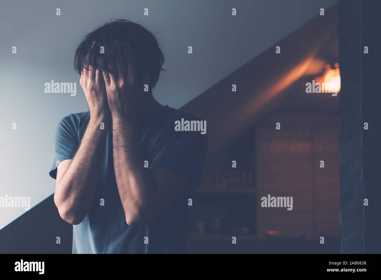Male midlife crisis depression stage concept, depressed man crying in loft apartment Stock Photo