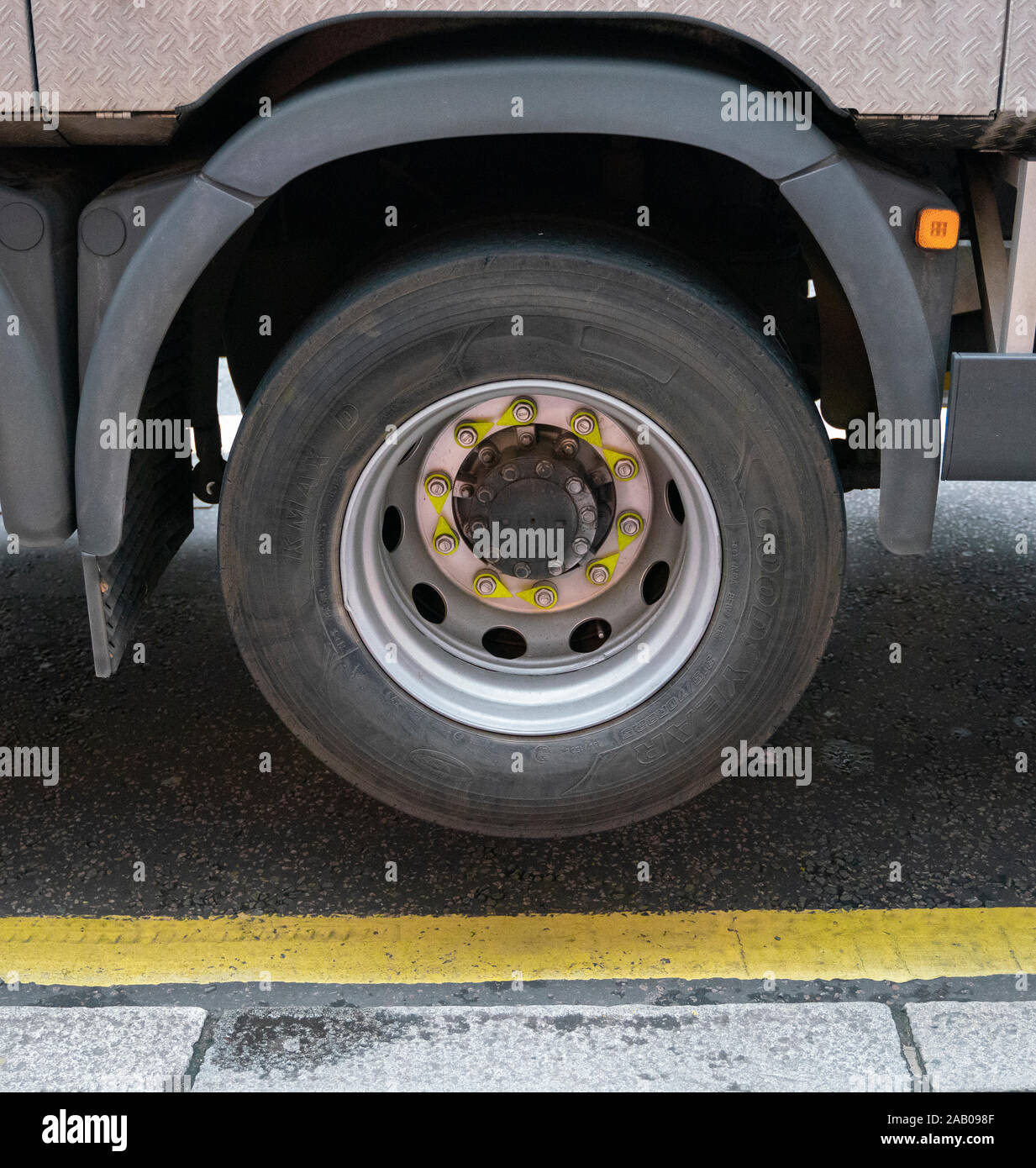 A truck wheel suspended over a yellow line Stock Photo