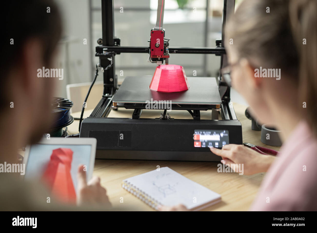 One of young managers pressing button on control panel of 3d printer Stock Photo