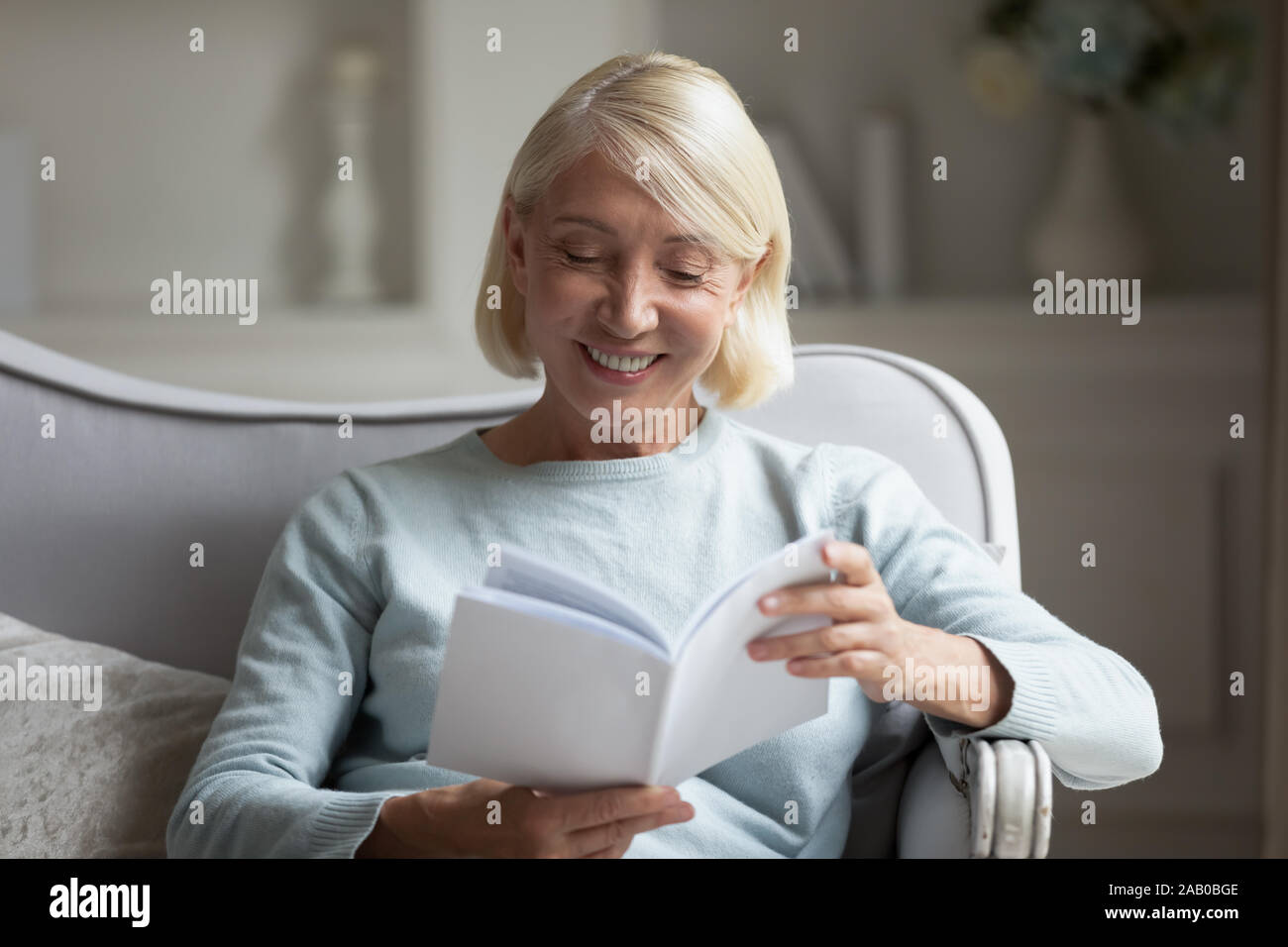 60s woman enjoy free time reading interesting book Stock Photo