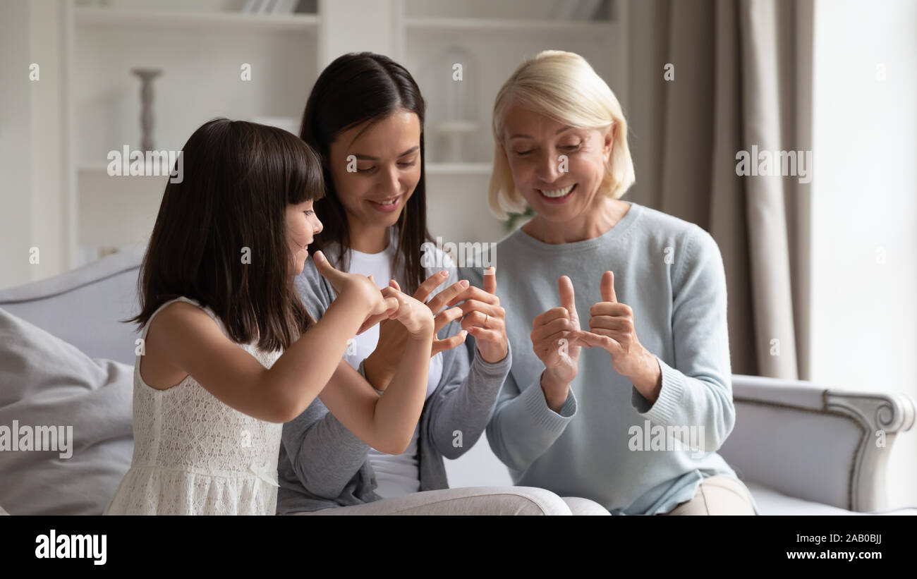 Multi generational family sitting on couch communicating using sign