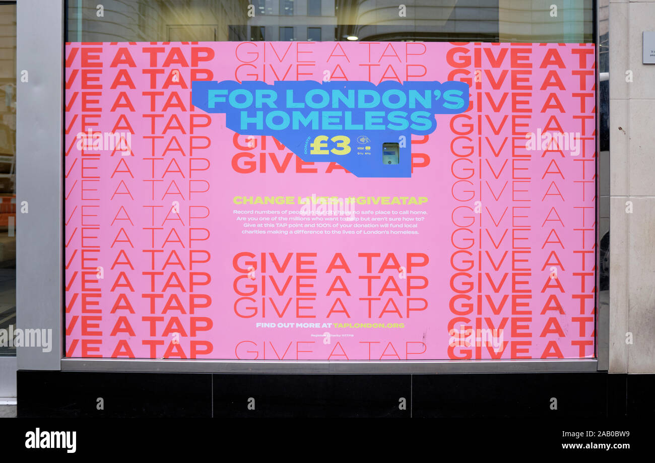 Window billboard set up with a pay tap asking for a £3 donation for London's Homeless, with slogan 'Give a Tap' Stock Photo