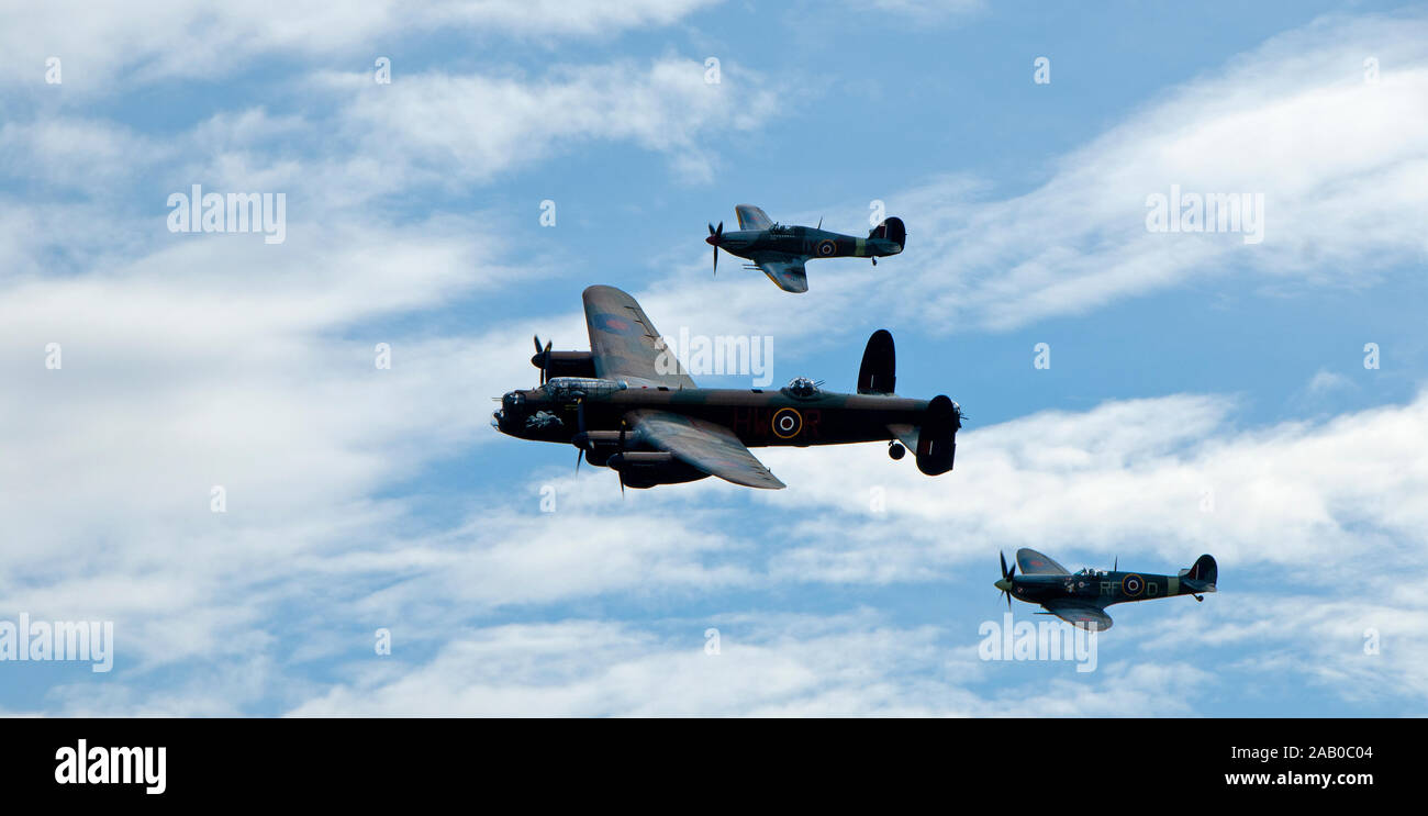 Duxford Battle of Britain flypast by an Avro Lancaster, Spitfire and Hurricane. Stock Photo