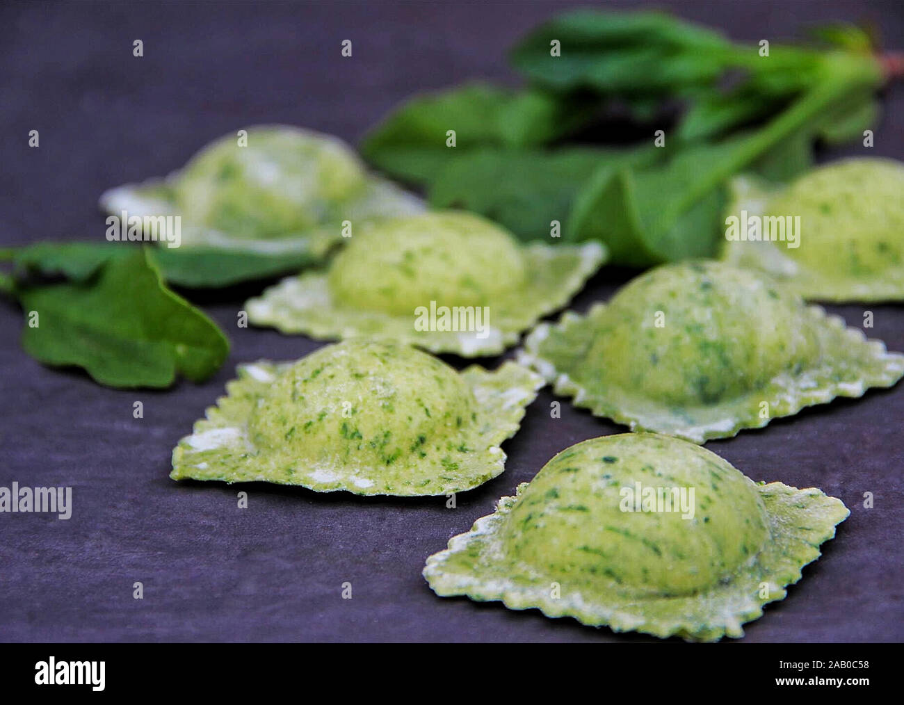 Raw ravioli with spinach on dark background Stock Photo - Alamy