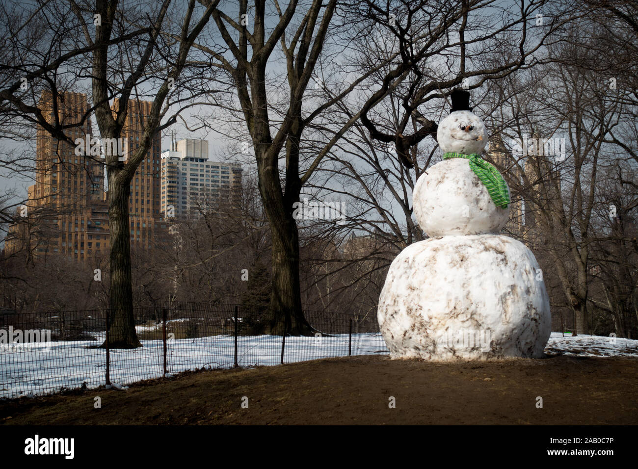 Giant Snowman With Carrot Nose And Green Scarf Standing On Green Grass