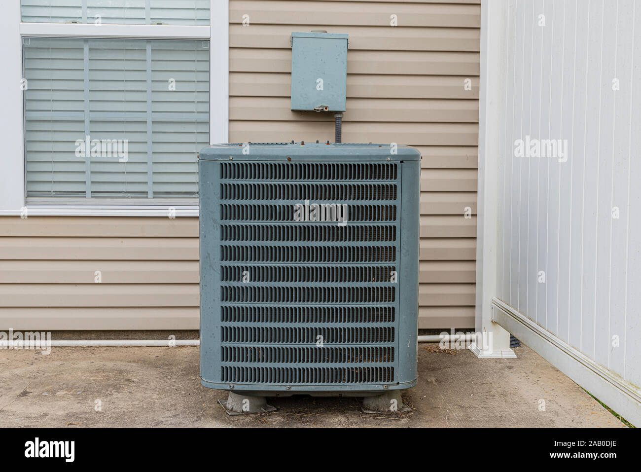 Horizontal shot of an air conditioning unit on the patio behind a condo