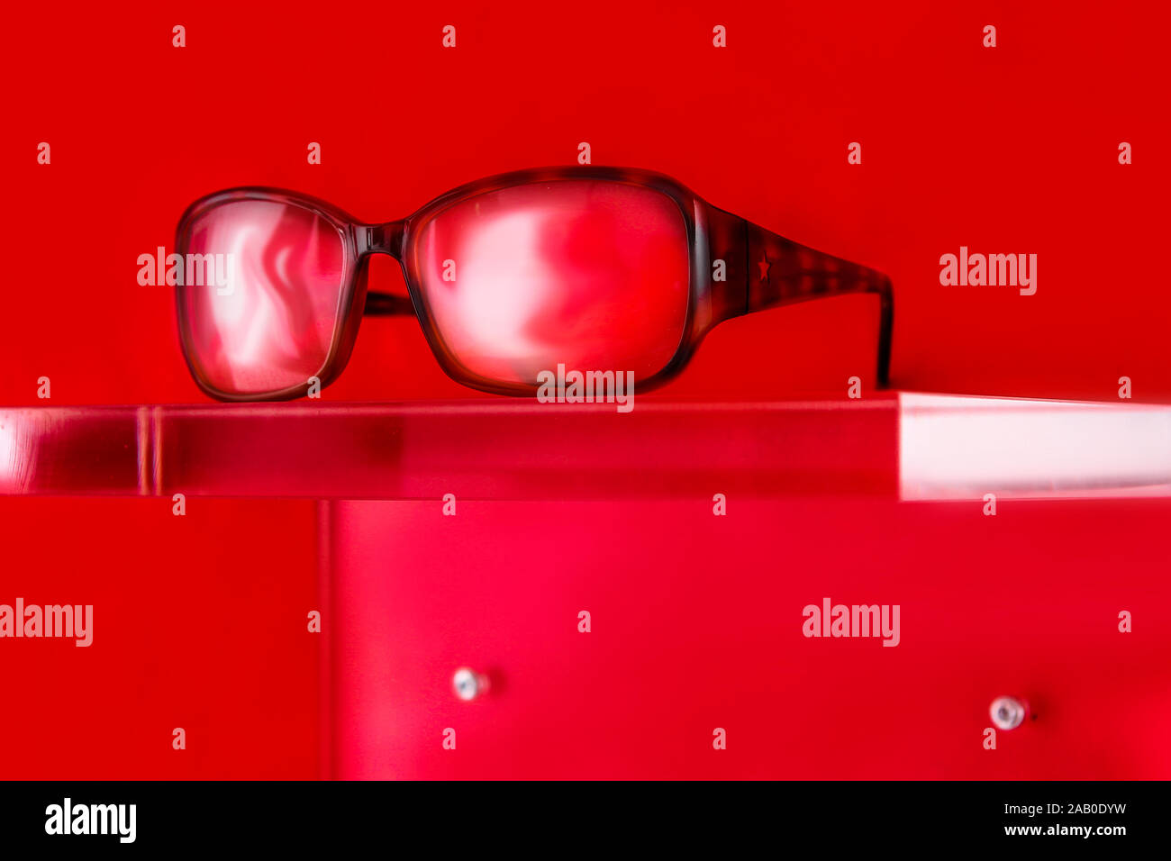 glasses on a plexiglass display with red background Stock Photo Alamy