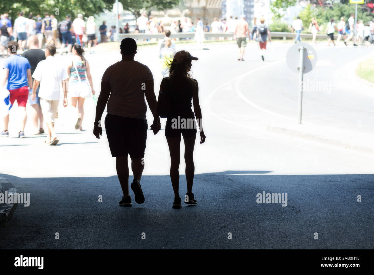 Different body types. Silhouette of a young couple walking hand by hand. Stock Photo