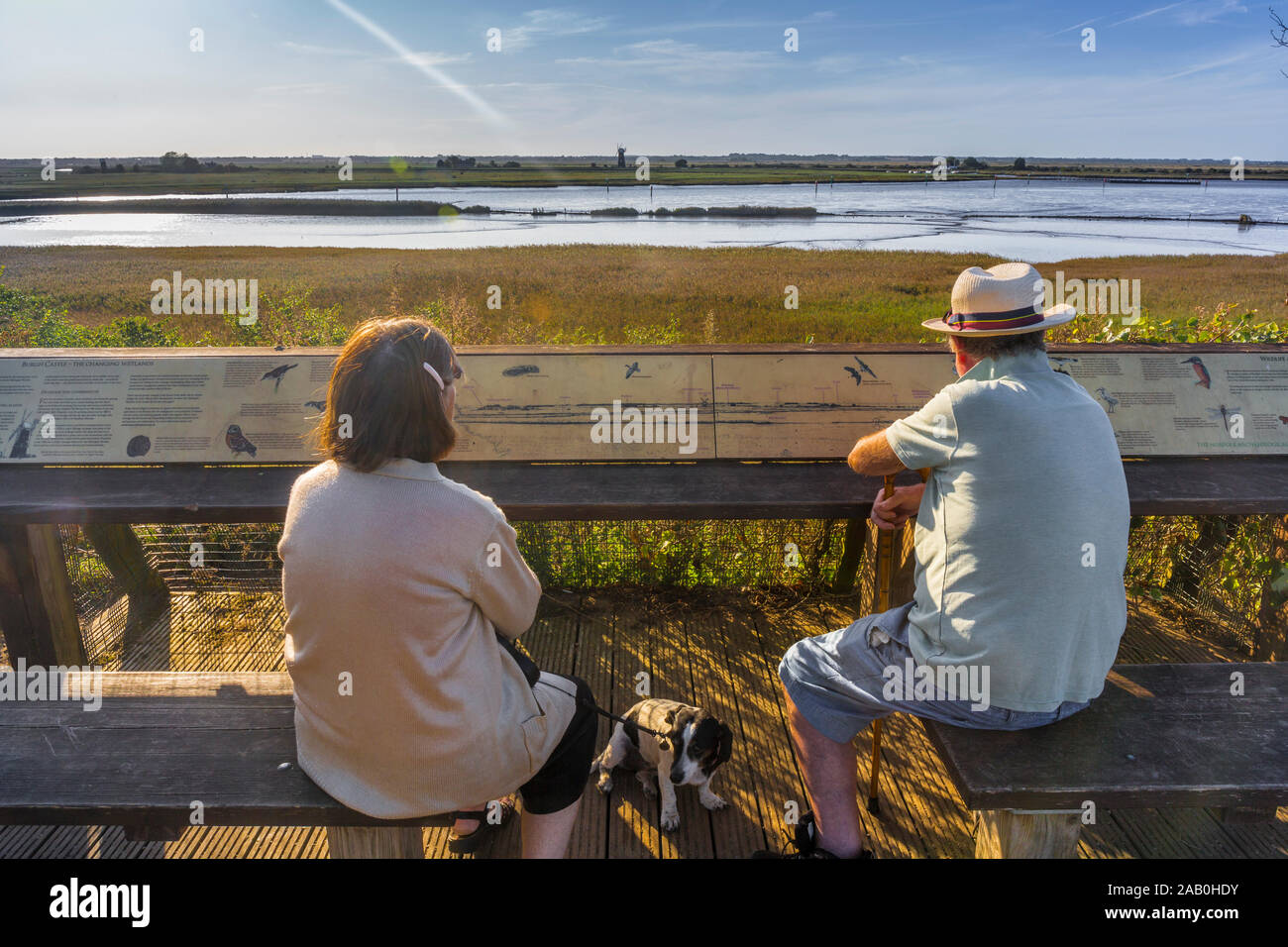 Walkers pause to admire the view at Burgh Castle, Norfolk, UK, where the rivers Waveney and Yare meet part of The Norfolk Broads. Stock Photo
