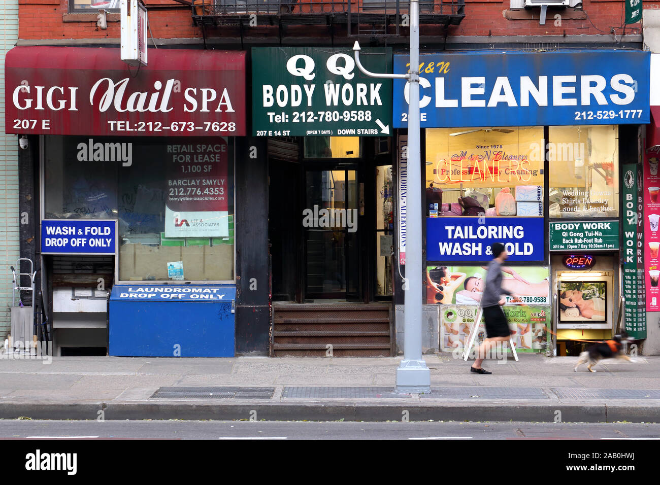 Laundromat and massage parlor storefronts along East 14th St in the East Village neighborhood of Manhattan in New York, NY. Stock Photo