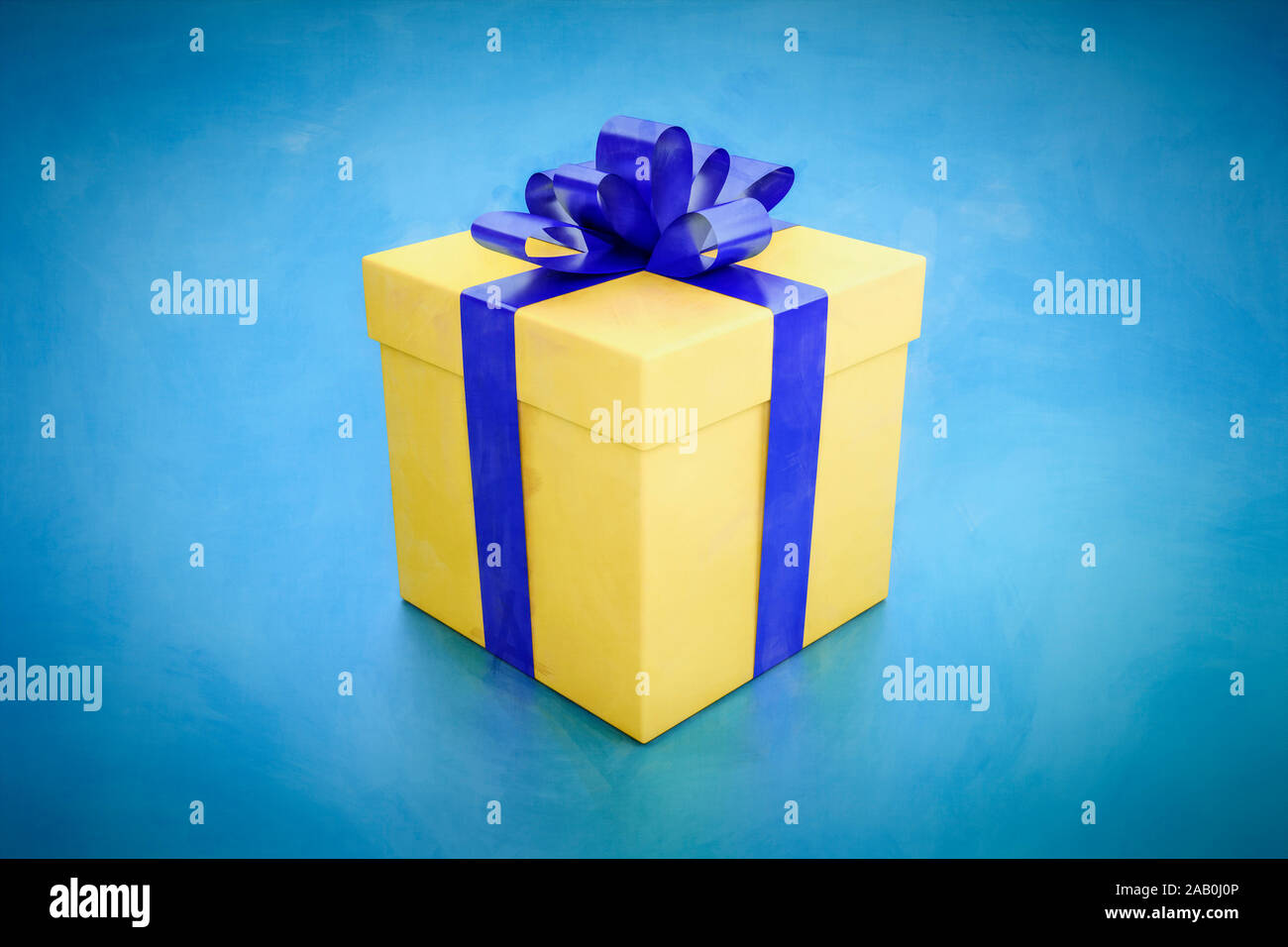 Eine gelbe Geschenkbox mit blauer Schnur vor blauem Hintergrund Stock Photo