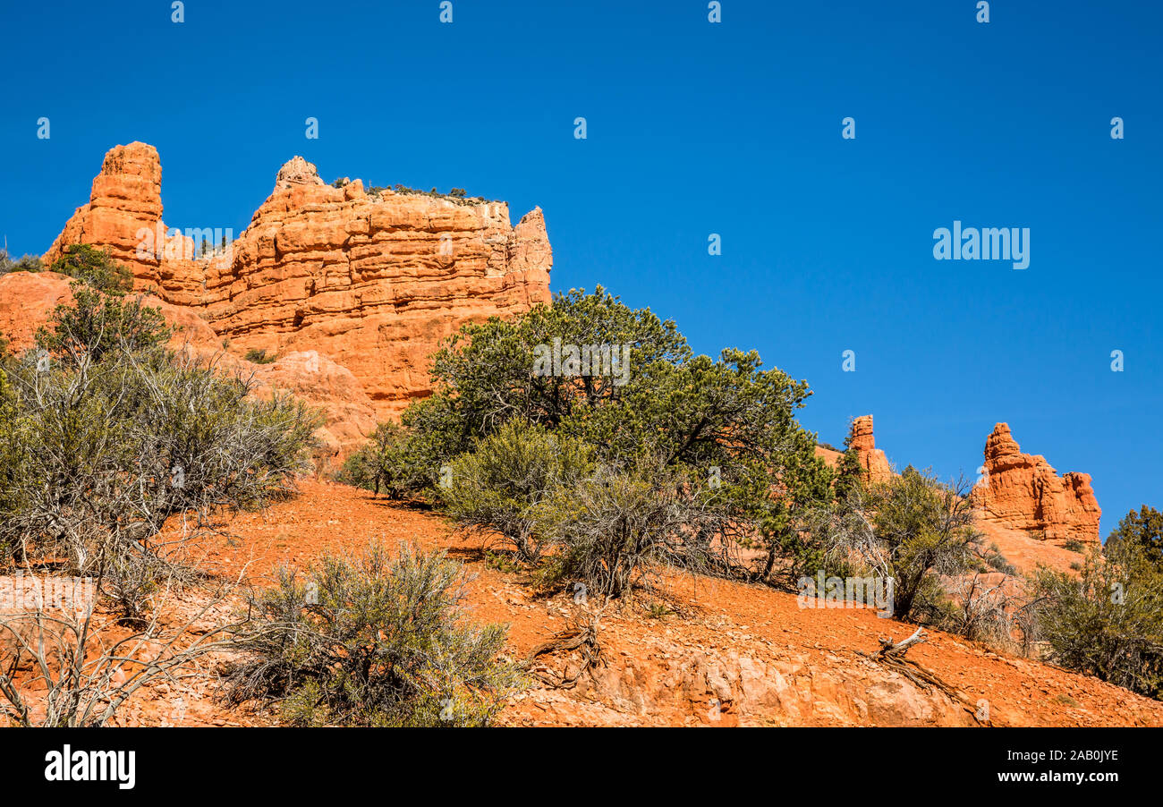Cliff of red rock sandstone and detatched towers in the southern Utah desert near Brian Head and Cedar Breaks National Monument. Stock Photo