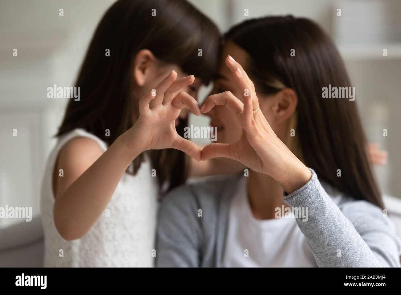 Mothers and daughters fingers showing heart symbol of love Stock Photo