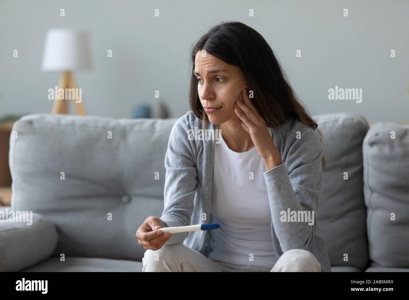 Woman feels frustrated about positive test and unplanned pregnancy Stock Photo