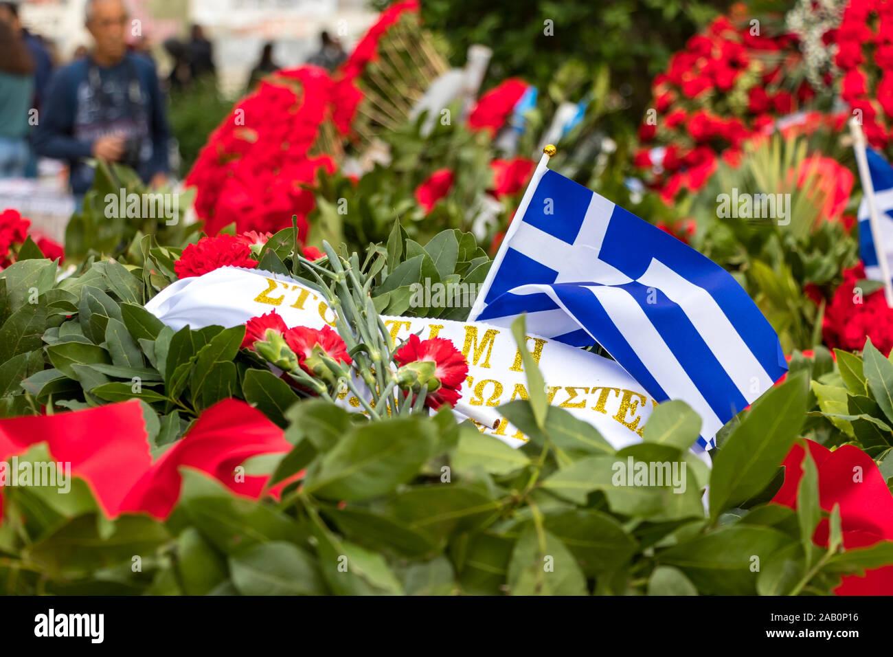 Red flowers and greek flags to conmemorate the 46th aniversary of the uprising students against the Greek junta in 1973. Stock Photo