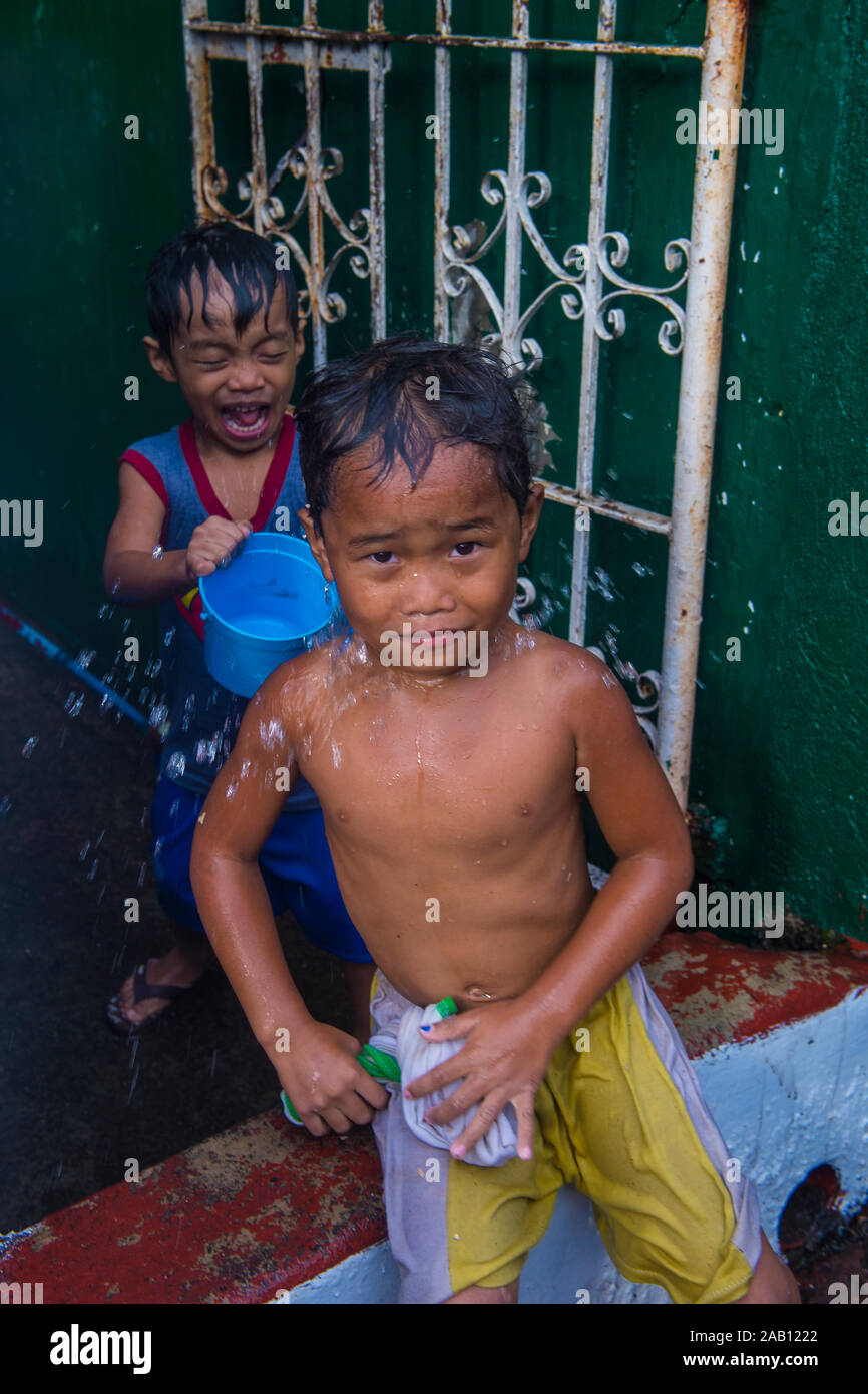 A child is playing with water during Higantes festival in Angono Philippines Stock Photo