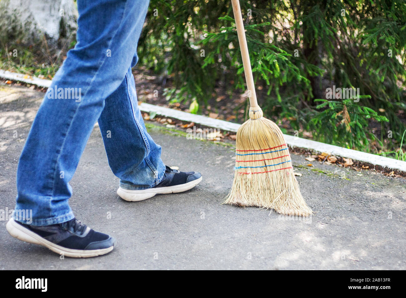Cleaning the area with a broom. A man is sweeping the street. Cleaning