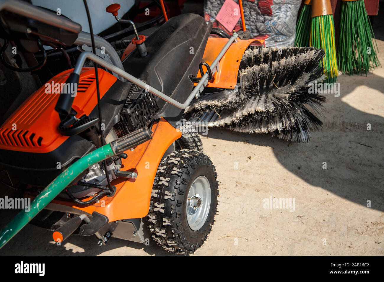 Harvesting equipment. Dust brushes mounted on a vehicle. Garage storage of motor equipment. All you need to clean the area. A man keeps tools in order Stock Photo