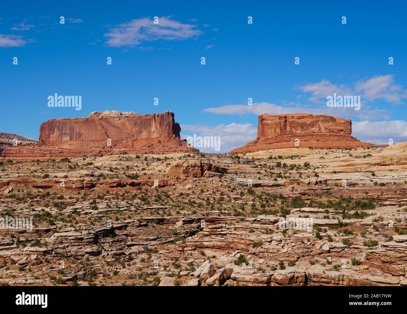 Large red rock sentinels quietly watch over the road to Canyonlands National Park. Stock Photo