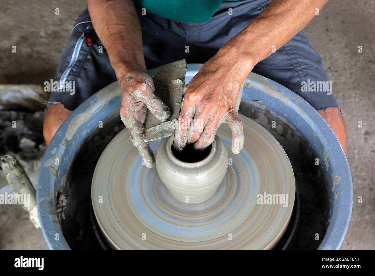 closeup of hands making pottery on pottery wheel Stock Photo