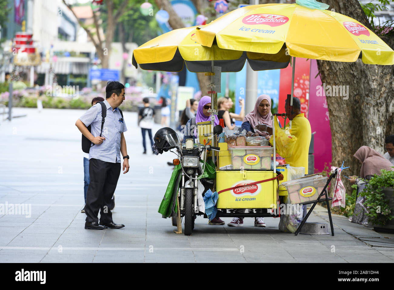 Some local people and tourists are buying ice cream from a street
