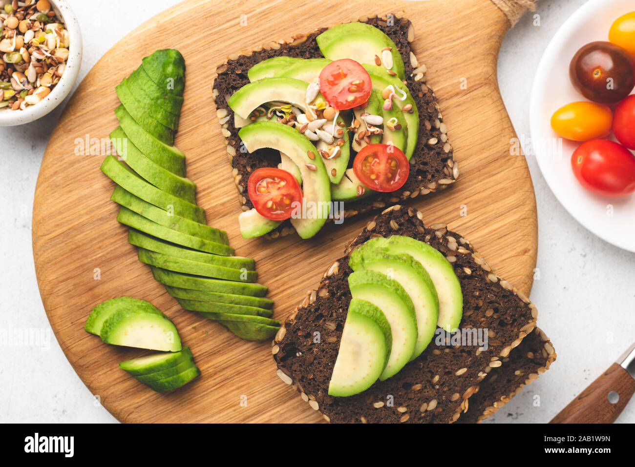 Rye bread toast with avocado, tomato, sprouts. Healthy food, vegan