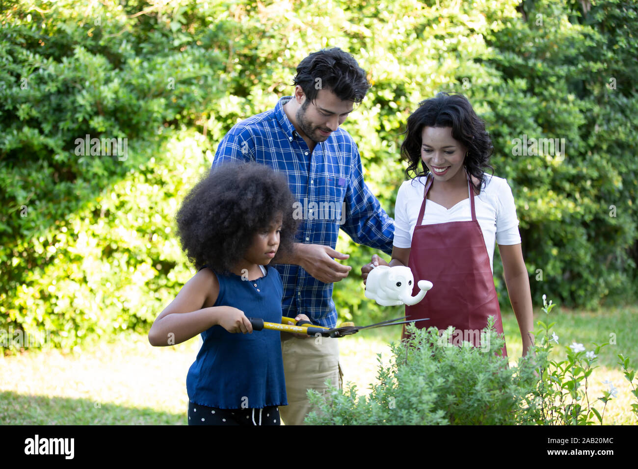 Young mixed race family playing in garden, father and daughter play game on holiday Stock Photo
