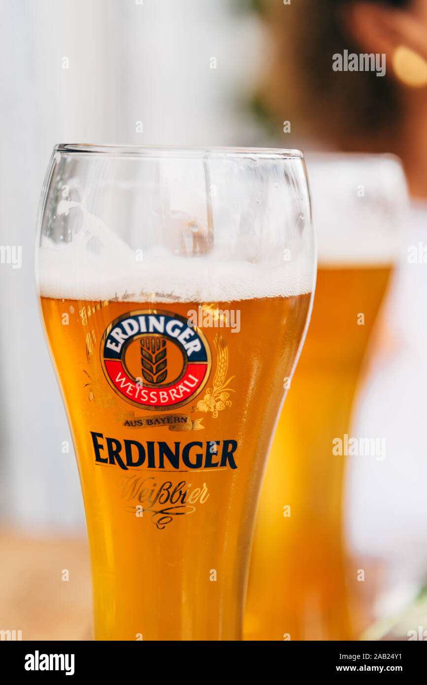 Hamburg, Germany - August 7, 2019: Glowing weiss glass of light Erdinger Beer on a restaurant terrace. Bokeh background. Stock Photo