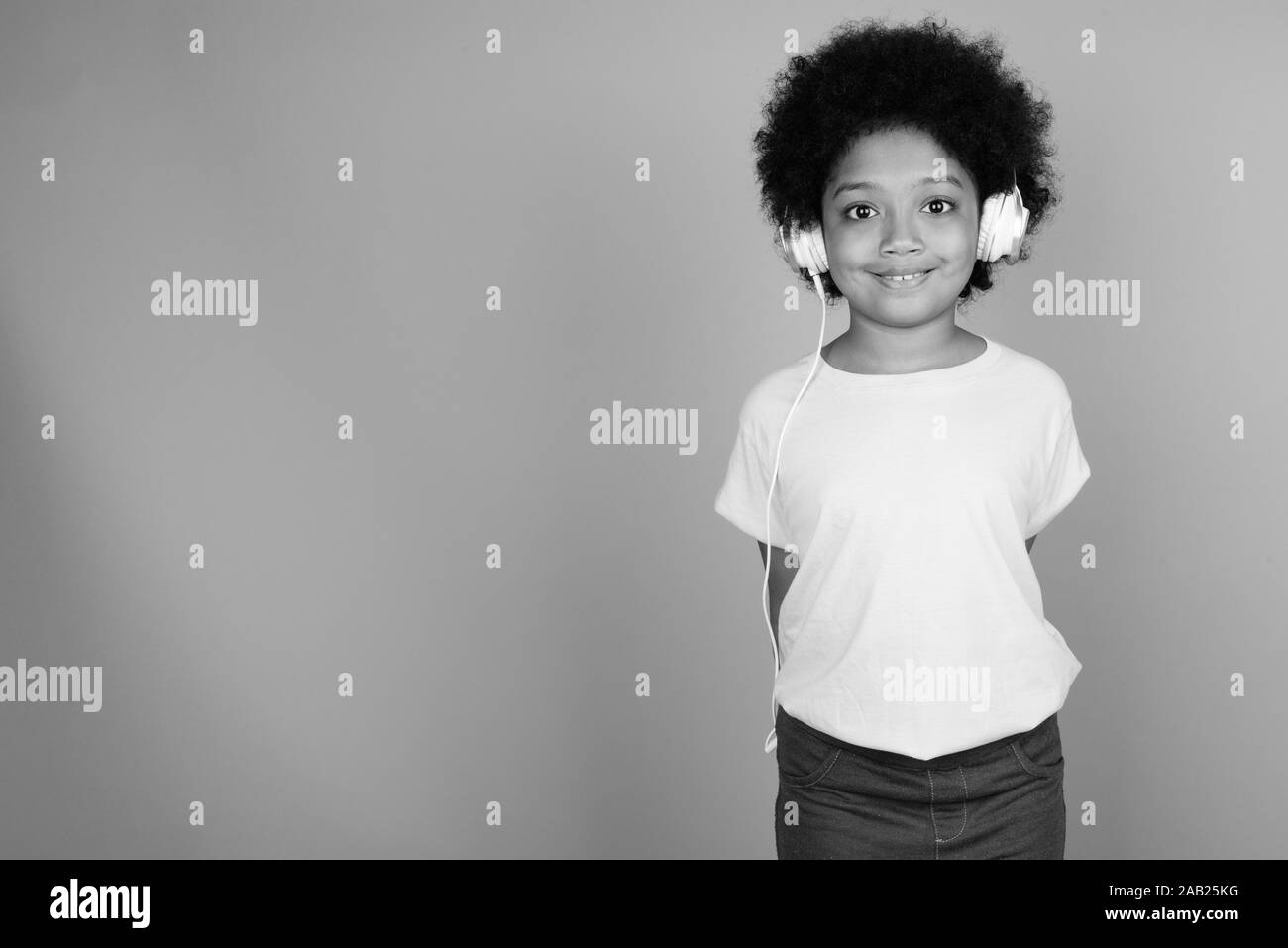 Young Cute African Girl With Afro Hair Listening To Music In Black