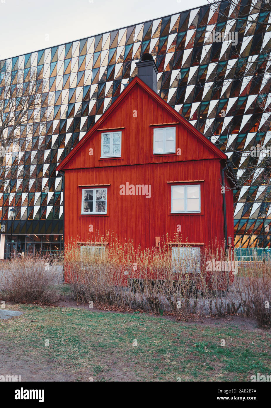 Traditional timber Falun red house in front of the Aula Medica, Karolinska Institute (Karolinska Institutet), Solna, Stockholm, Sweden Stock Photo