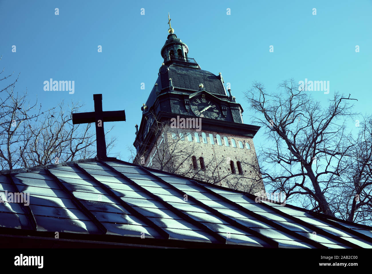 Strangnas Cathedral (Strangnas Domkyrka) tower and cross above ice covered roof, Strangnas, Sodermanland County, Sweden Stock Photo