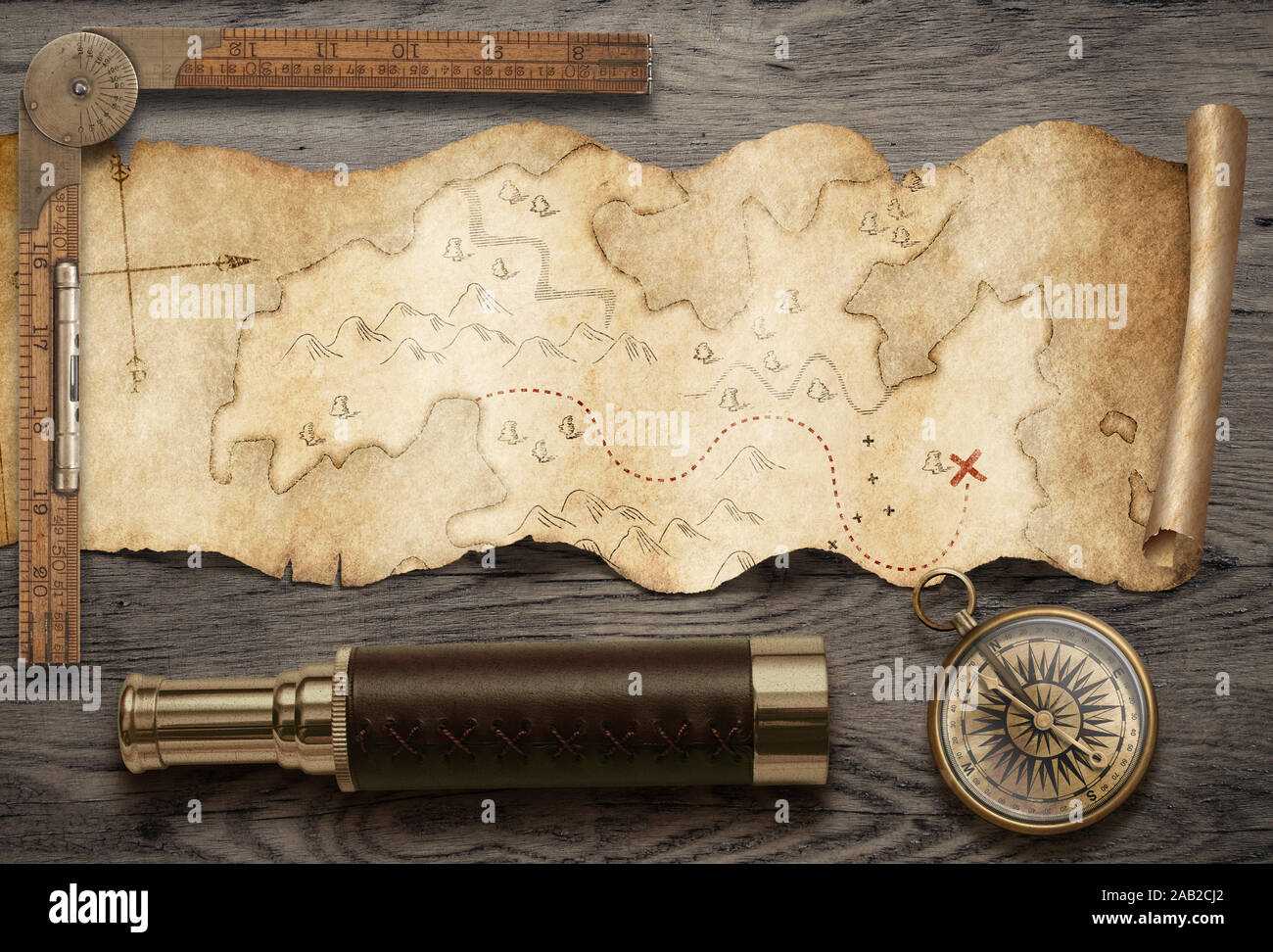 Old torn treasure map with compass and spyglass top view. Adventure and travel concept. Stock Photo