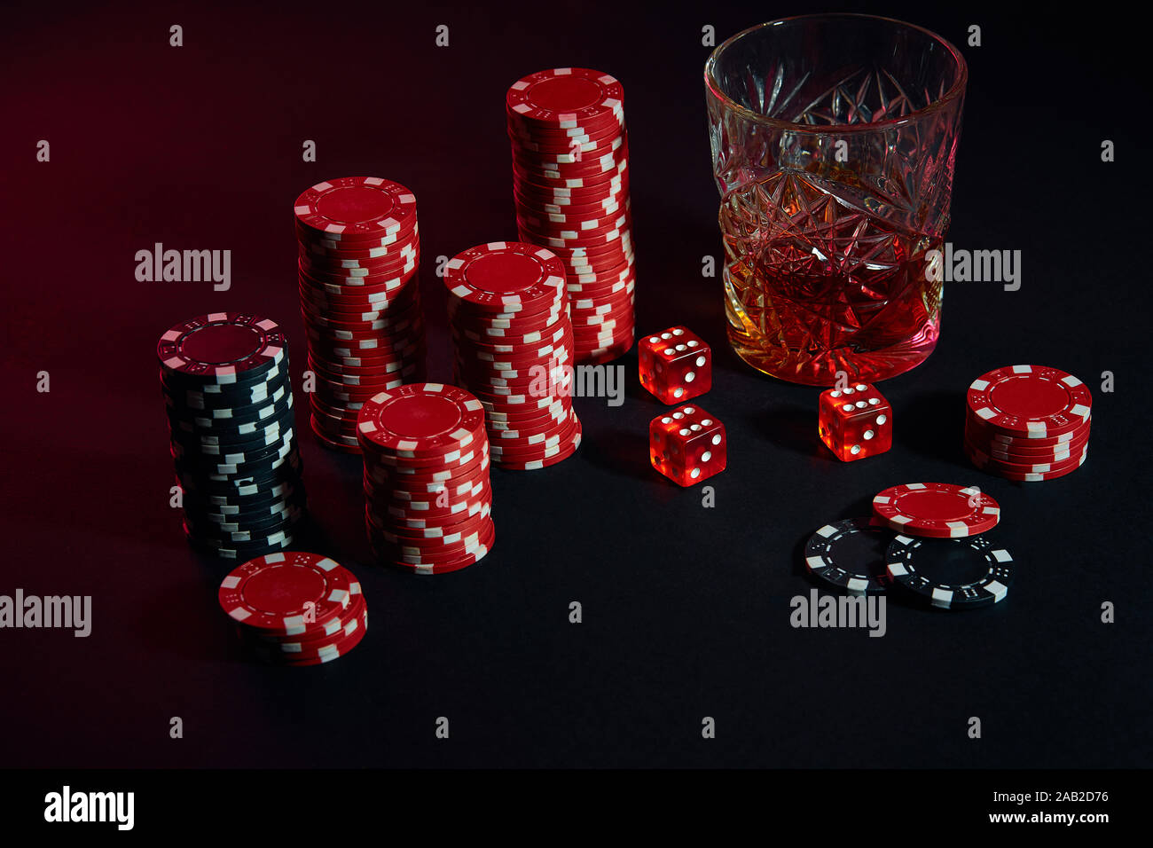 Poker chips and wine glass of cognac on dark table. Gambling Stock