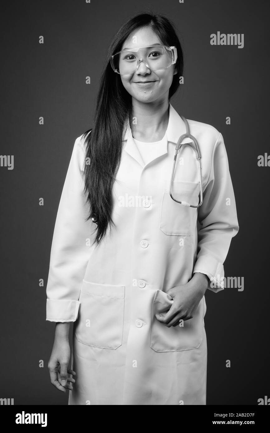 Young beautiful Asian woman doctor as scientist in black and white ...