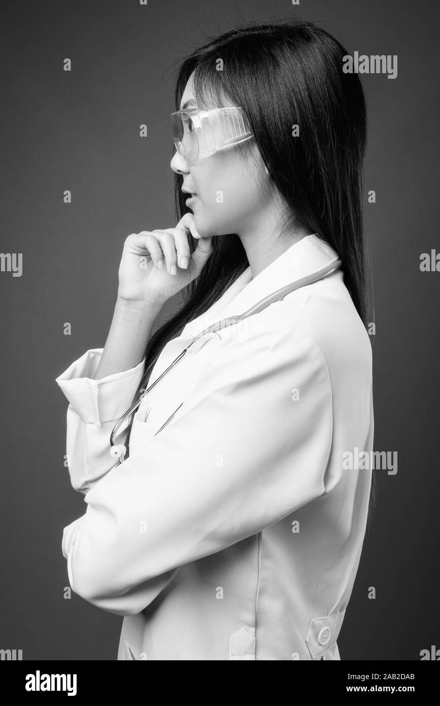 Young beautiful Asian woman doctor as scientist in black and white ...