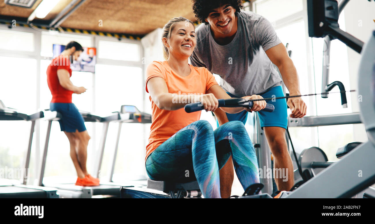 Young beautiful woman doing exercises with personal trainer Stock Photo