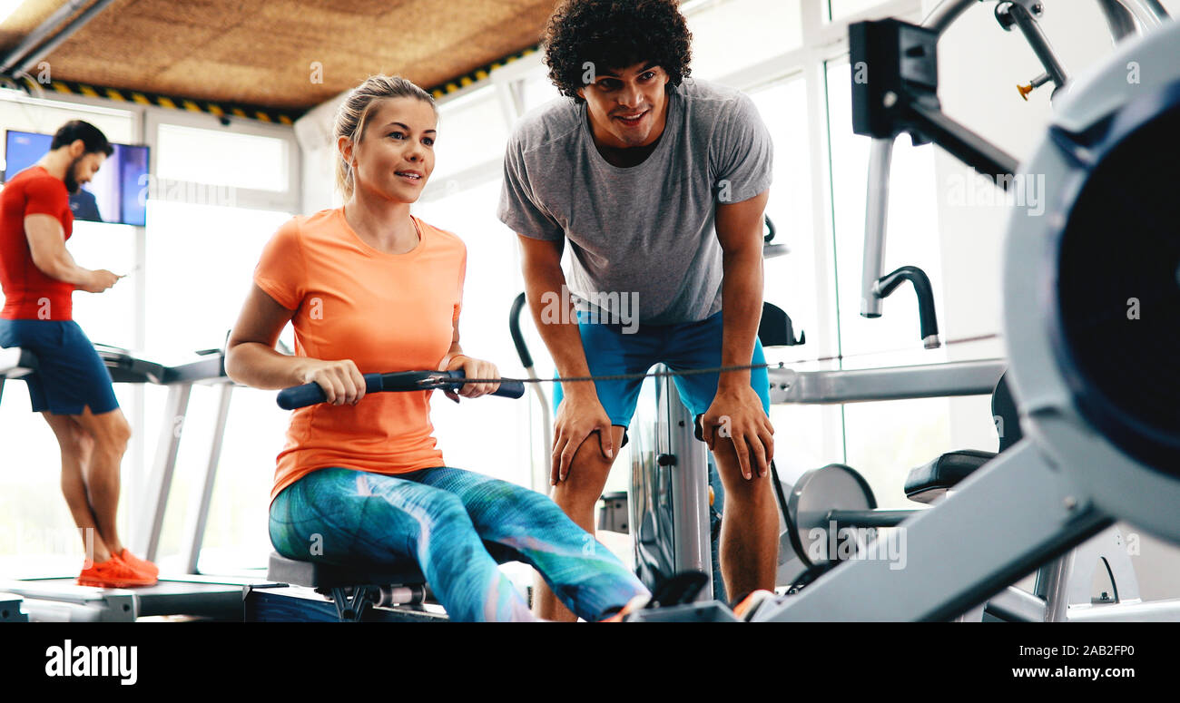 Young beautiful woman doing exercises with personal trainer Stock Photo