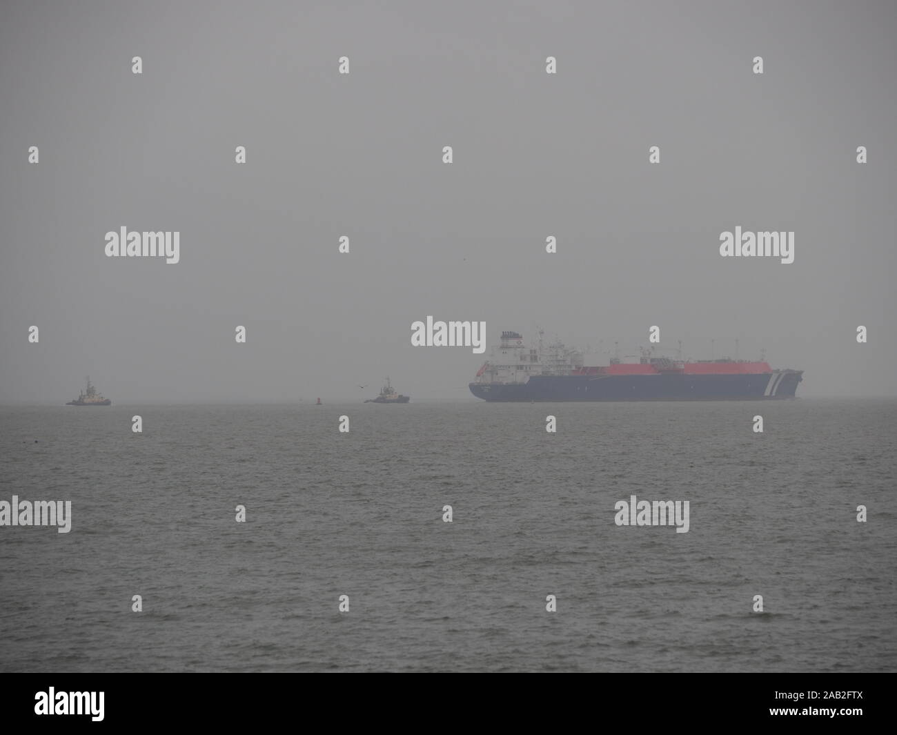 Sheerness, Kent, UK. 25th November, 2019. UK Weather: a grey, misty and overcast start to the week in Sheerness, Kent. Norwegian LNG gas carrier Wilpride departs. Credit: James Bell/Alamy Live News Stock Photo