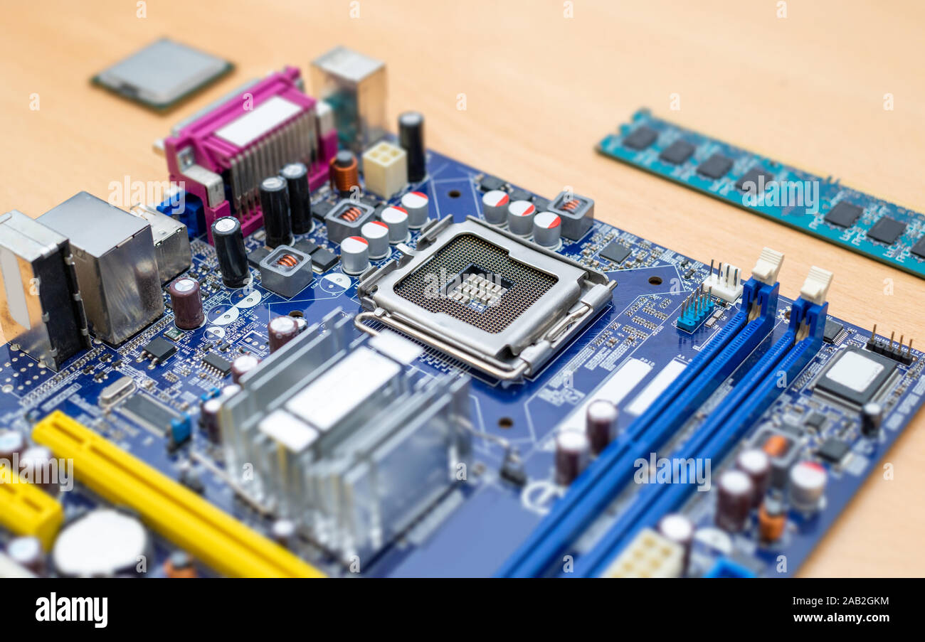 LGA socket on motherboard close-up. Blue motherboard. Processor and ram module beside. Stock Photo