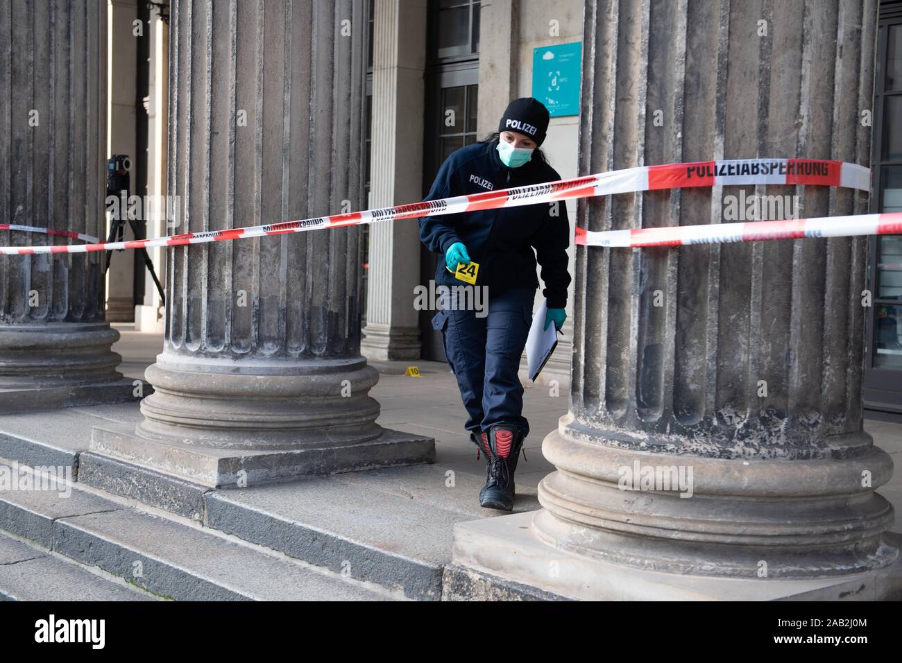 Dresden, Germany. 25th Nov, 2019. A policewoman walks in front of the building of the Schinkelwache behind a barrier tape. Dresden's Treasury Green Vault was broken into early in the morning. The break-in affects the historical part of the valuable collection. Credit: Sebastian Kahnert/dpa-Zentralbild/dpa/Alamy Live News Stock Photo