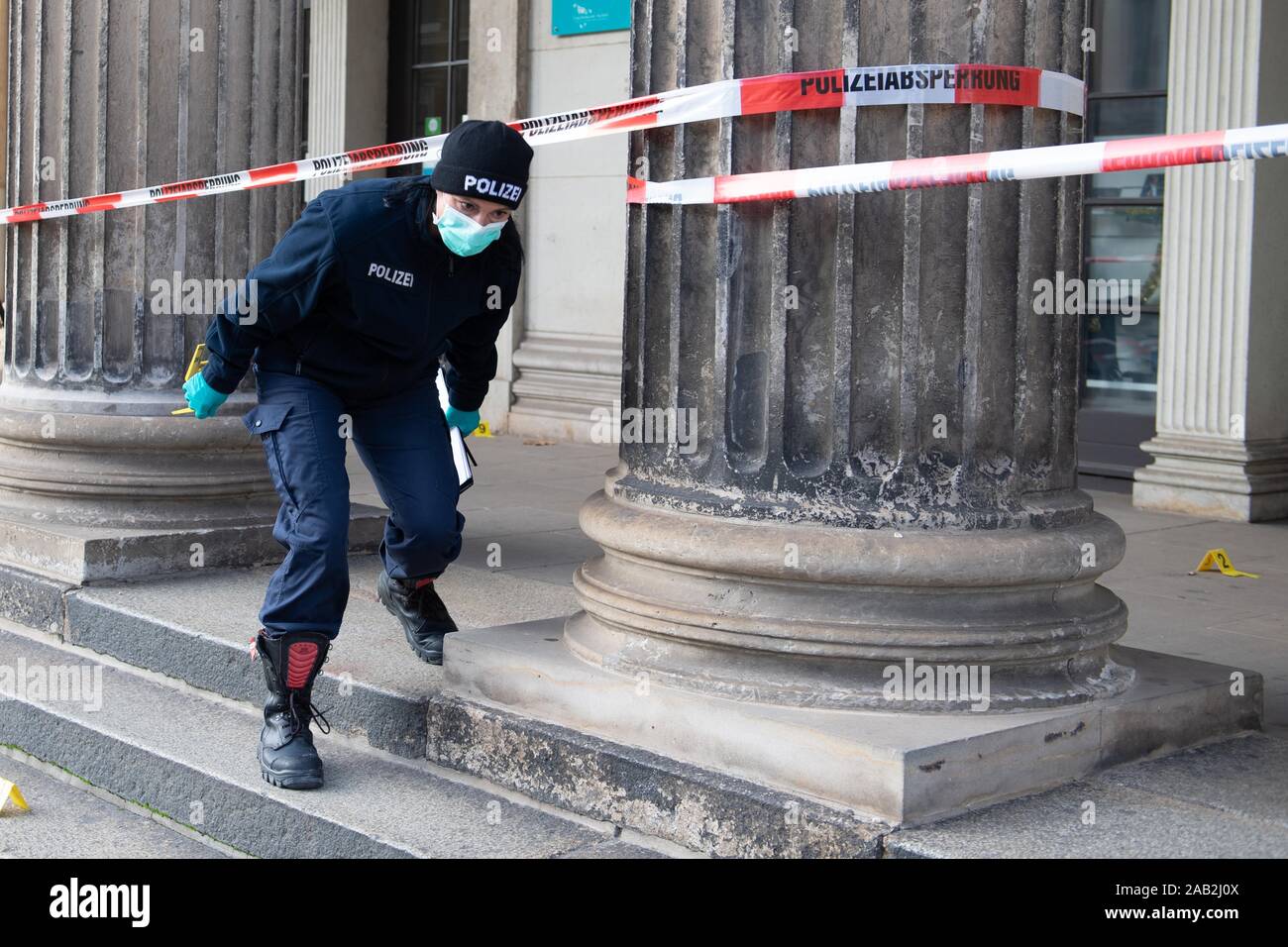 Dresden, Germany. 25th Nov, 2019. A police woman walks under a barrier tape in front of the Schinkelwache building. Dresden's Treasury Green Vault was broken into early in the morning. The break-in affects the historical part of the valuable collection. Credit: Sebastian Kahnert/dpa-Zentralbild/dpa/Alamy Live News Stock Photo