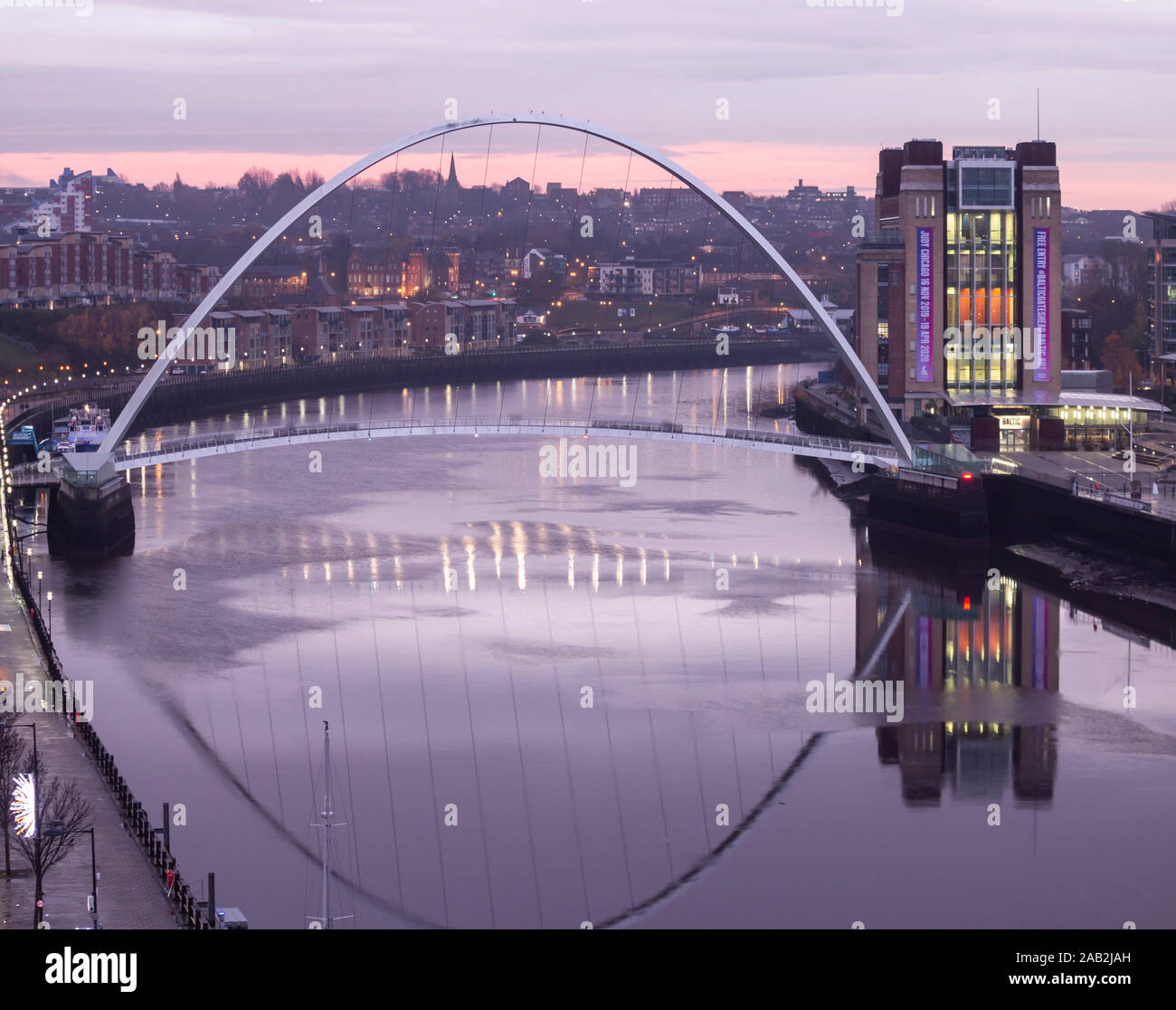 Newcastle upon Tyne, England, UK. 25th November, 2019. Weather: View over river tyne and Gateshead Millennium bridge at sunrise on a grey, drizzly early morning in the north east. Credit: Alan Dawson /Alamy Live News Stock Photo