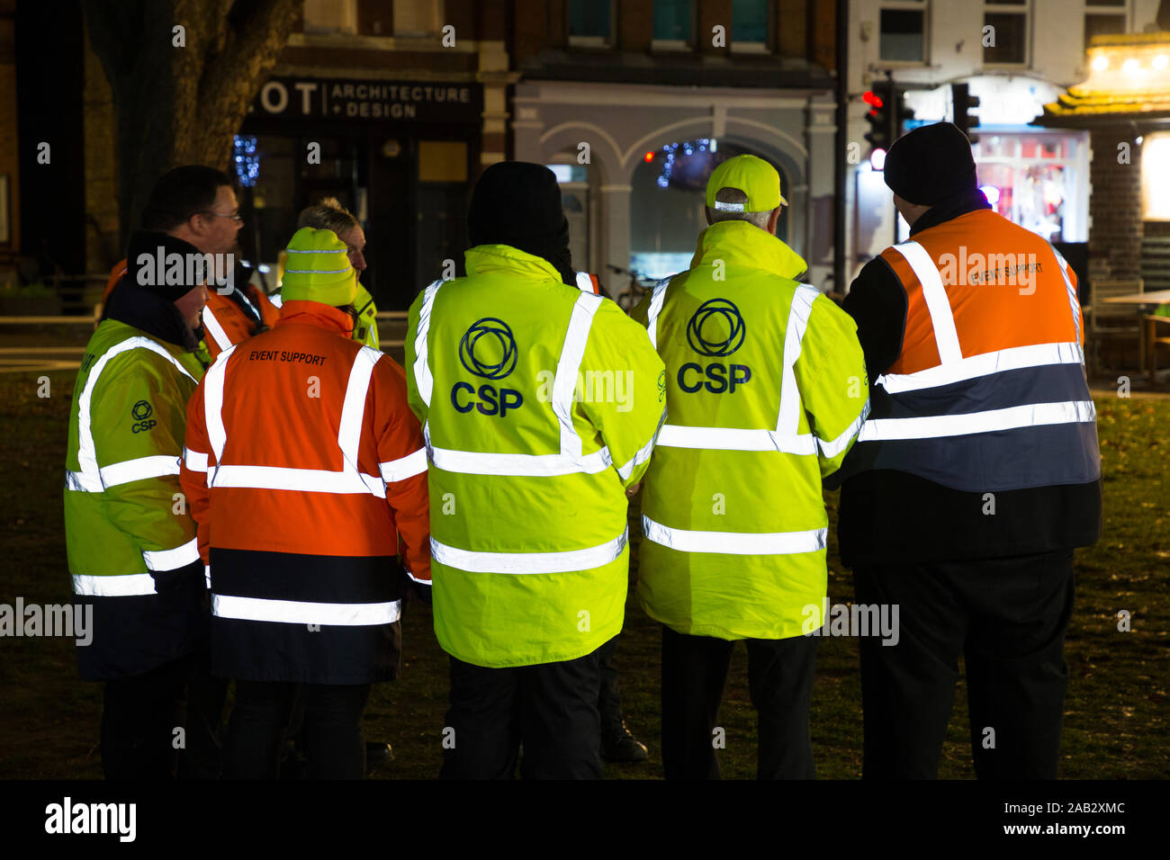 Event stewards in orange, yellow jacket / green hi vis / high visibility jackets with highly reflective stripes / material strips. UK (114) Stock Photo