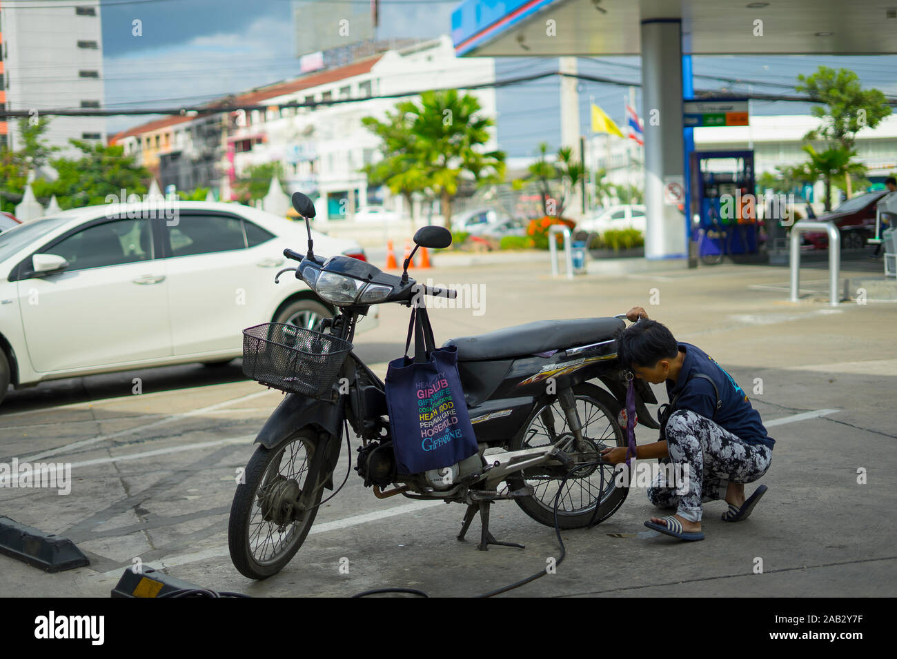 CHIANGMAI,THAILAND-Nov 14, 2019 :  Thai man biker inflating the tire of motobike. in PTT Gas station. Stock Photo