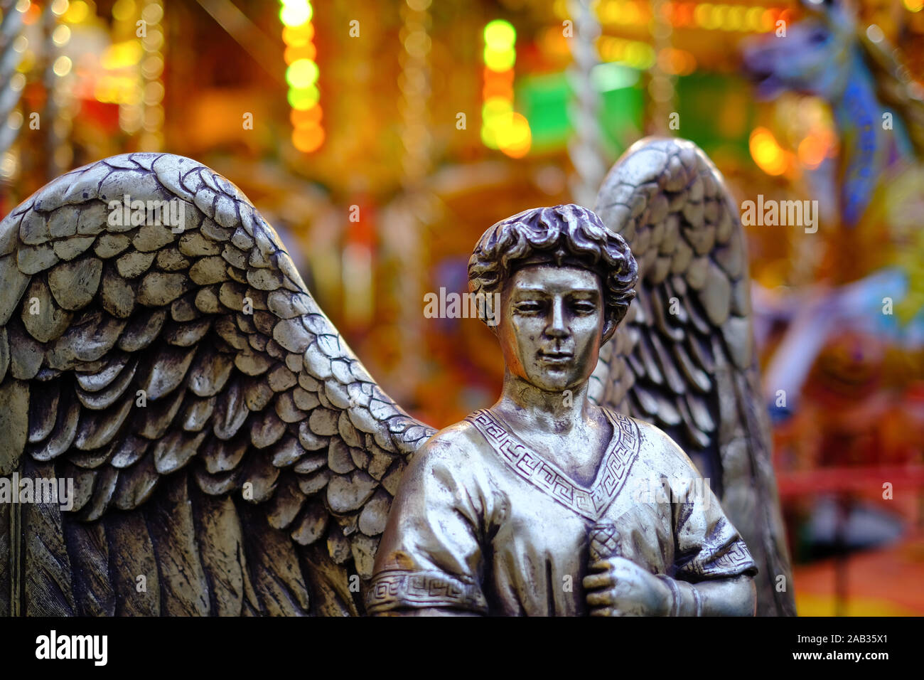 An angel stands guard in front of a traditional carousel ride at Blenheim Palace Stock Photo